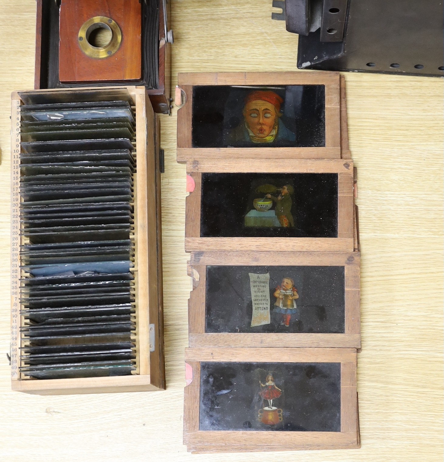 A magic lantern and a quantity of glass slides, including eleven novelty moving painted slides